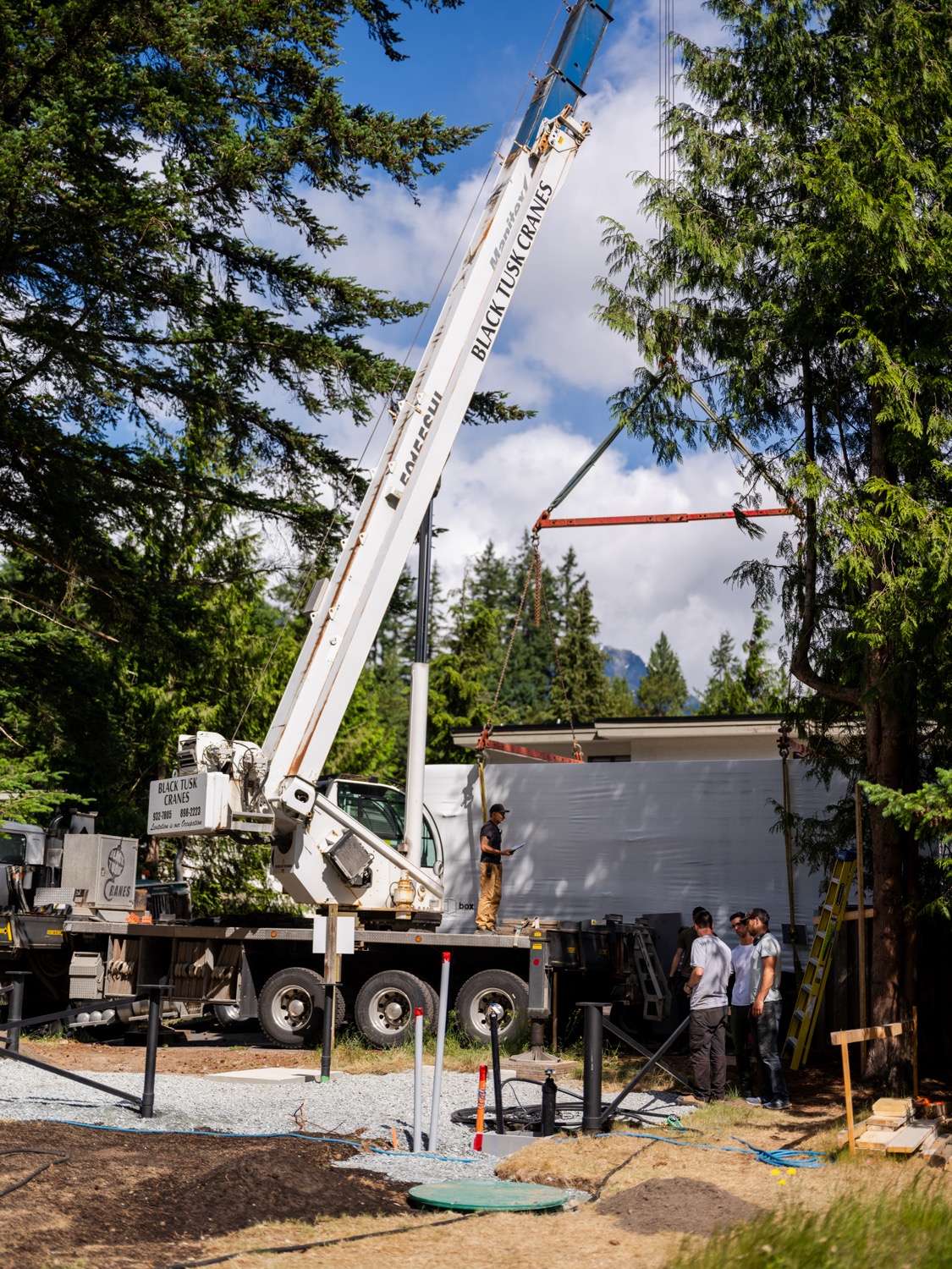 Crew standing on a wrapped ADU module under the crane